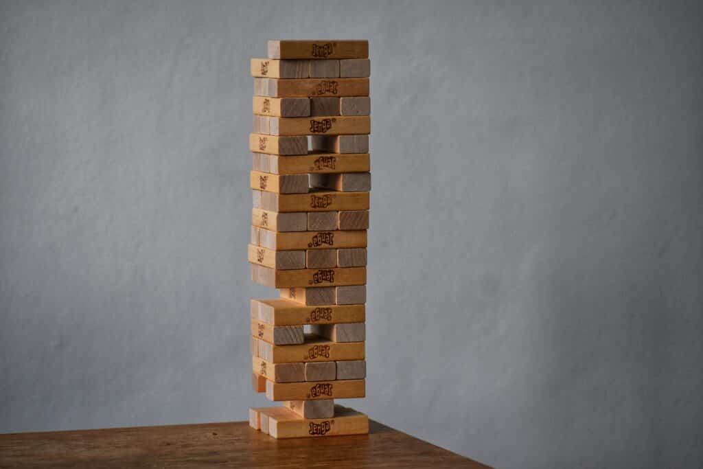 Imagem de blocos do jogo Jenga empilhados e em equilíbrio. O intuito é representar a base, assim como o topo.