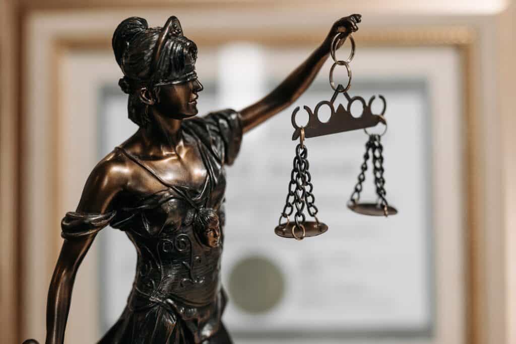 Imagem do símbolo do Direito: uma figura feminina de bronze segurando uma balança.